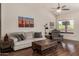 Comfortable living room featuring a ceiling fan, desert artwork, and a comfortable sofa and recliner at 7762 E Russell Cir, Mesa, AZ 85207