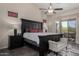 This main bedroom boasts a dark wood bed frame, ceiling fan, and outdoor access at 7762 E Russell Cir, Mesa, AZ 85207