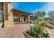 Tiled patio features stone columns, potted plants, and wrought iron table with chairs for outdoor dining at 7762 E Russell Cir, Mesa, AZ 85207