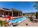 Relaxing pool area, complete with a hot tub, a built-in basketball hoop, and mountain views in the background at 7762 E Russell Cir, Mesa, AZ 85207