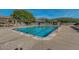 Beautiful view of the community pools, surrounded by lush landscaping and shaded seating areas at 7762 E Russell Cir, Mesa, AZ 85207