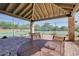 Covered patio near community tennis courts with tables, chairs, and views of the tennis court and surrounding greenery at 7762 E Russell Cir, Mesa, AZ 85207
