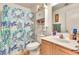 Compact bathroom featuring a shower, vanity, and toilet with patterned shower curtain at 871 N Granada Dr, Chandler, AZ 85226