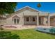 Expansive backyard showcasing a covered patio, manicured lawn, and neutral stucco exterior at 9563 E Keats Ave, Mesa, AZ 85209