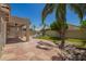 Serene backyard retreat with a covered patio, lush lawn, rock features, and mature landscaping at 9563 E Keats Ave, Mesa, AZ 85209