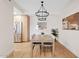 Cozy dining room with modern light fixture, wood table set, and an open view into the kitchen at 9708 E Via Linda Rd # 1350, Scottsdale, AZ 85258
