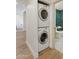 Stacked white washer and dryer, and doorway to bathroom with green tile at 9708 E Via Linda Rd # 1350, Scottsdale, AZ 85258