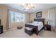 A relaxing bedroom with a large window, a ceiling fan and neutral colors at 102 W Raven Dr, Chandler, AZ 85286