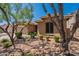Attractive single-story home with desert landscaping, rocks and lush green bushes at 102 W Raven Dr, Chandler, AZ 85286