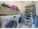 Functional laundry room with modern washer and dryer, and shelving for ample storage at 102 W Raven Dr, Chandler, AZ 85286
