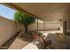 Inviting covered backyard patio with seating area, landscaped yard, and privacy wall at 10505 W Campana Dr, Sun City, AZ 85351