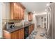 Well-lit kitchen featuring brown wood cabinetry, tile backsplash and stainless steel refrigerator at 10505 W Campana Dr, Sun City, AZ 85351