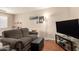 Cozy living room features a plush sofa, wood floors and a large television at 10505 W Campana Dr, Sun City, AZ 85351