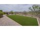 A neatly maintained backyard with artificial grass, rock ground cover, and mountain views at 11470 E Yeager Cyn, Gold Canyon, AZ 85118
