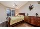 Serene bedroom with light, neutral walls, ceiling fan and a stylish wood dresser at 12754 E Laurel Ln, Scottsdale, AZ 85259