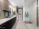 Elegant bathroom featuring a walk-in shower, double vanity, and walk-in closet at 13406 W Rowel Rd, Peoria, AZ 85383