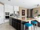 Modern kitchen with a breakfast bar, stainless steel appliances, and dark wood accents at 13406 W Rowel Rd, Peoria, AZ 85383
