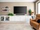 Modern living room features custom built-ins, floating shelves and a mounted television at 13406 W Rowel Rd, Peoria, AZ 85383