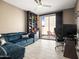 Comfortable living room with a sectional sofa, ceiling fan, and sliding glass doors to the patio at 13406 W Rowel Rd, Peoria, AZ 85383