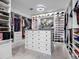 Bright walk-in closet offering custom shelving, clothing racks and a center island for extra storage at 13406 W Rowel Rd, Peoria, AZ 85383