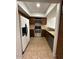 A galley kitchen with tile flooring and dark wood cabinets, and updated appliances at 14002 N 49Th Ave # 1120, Glendale, AZ 85306
