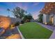 Backyard featuring a manicured lawn, mature trees, and stone pathways at 14014 N 57Th Way, Scottsdale, AZ 85254