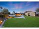 A backyard with a pool, lush green lawn, and landscape lighting for evening enjoyment at 14014 N 57Th Way, Scottsdale, AZ 85254