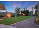 Backyard featuring a manicured lawn, mature trees, and stone pathways, perfect for relaxation and outdoor enjoyment at 14014 N 57Th Way, Scottsdale, AZ 85254