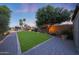 This is a backyard featuring a manicured lawn, mature trees, and stone pathways at 14014 N 57Th Way, Scottsdale, AZ 85254