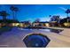 Twilight view of the backyard oasis featuring a sparkling pool, spa, and ambient lighting at 14014 N 57Th Way, Scottsdale, AZ 85254
