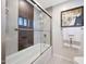 Shower and tub combination with glass doors and elegant tile surround, plus white towels at 14014 N 57Th Way, Scottsdale, AZ 85254