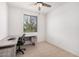 Office space featuring a desk, ceiling fan, tiled floor, and natural light through the window at 14253 W El Cortez Pl, Surprise, AZ 85387
