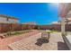 Beautiful backyard with brick patio, gravel, and garden bed, perfect for outdoor entertaining and relaxation at 14253 W El Cortez Pl, Surprise, AZ 85387