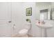 This cozy bathroom features a pedestal sink, a toilet, and simple wall art at 14253 W El Cortez Pl, Surprise, AZ 85387