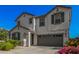Charming two-story home features a two-car garage and front yard landscaping with flowering plants at 14253 W El Cortez Pl, Surprise, AZ 85387