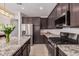 Modern kitchen featuring granite countertops, stainless steel appliances, and a kitchen island at 14253 W El Cortez Pl, Surprise, AZ 85387