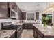 This spacious kitchen features granite countertops and dark cabinets with stainless steel appliances at 14253 W El Cortez Pl, Surprise, AZ 85387