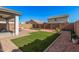 Inviting backyard with artificial grass, and brick patio area at 14253 W El Cortez Pl, Surprise, AZ 85387