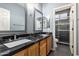 Bathroom featuring double sinks, granite counters, walk-in shower with glass door at 14604 W Banff Ln, Surprise, AZ 85379