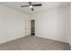 A simple bedroom with neutral-colored walls and carpet flooring and a ceiling fan at 14604 W Banff Ln, Surprise, AZ 85379