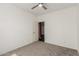 A simple bedroom with neutral-colored walls and carpet flooring, and a ceiling fan at 14604 W Banff Ln, Surprise, AZ 85379