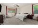 Spacious bedroom featuring a ceiling fan, comfortable sitting area, and bright window at 14604 W Banff Ln, Surprise, AZ 85379
