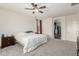 Relaxing bedroom featuring neutral carpet, a ceiling fan, and a convenient en suite bathroom at 14604 W Banff Ln, Surprise, AZ 85379