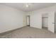 Open bedroom with neutral carpet and walls and doors that lead to the closet and bathroom at 14604 W Banff Ln, Surprise, AZ 85379