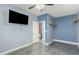 A bedroom with mounted shelves and a black television at 14604 W Banff Ln, Surprise, AZ 85379