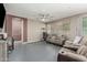 Living room with large sectional sofa, overhead fan, and a big window at 14604 W Banff Ln, Surprise, AZ 85379