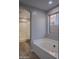 Bright bathroom featuring a soaking tub, a window, and tile flooring at 15067 W Taylor St, Goodyear, AZ 85338