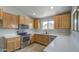 Open kitchen with stainless steel appliances, light wood cabinets, and granite countertops at 15067 W Taylor St, Goodyear, AZ 85338