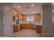 Open kitchen with stainless steel appliances, light wood cabinets, and granite countertops at 15067 W Taylor St, Goodyear, AZ 85338