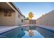 Sparkling pool surrounded by lush backyard landscaping, and a clear blue sky at 15067 W Taylor St, Goodyear, AZ 85338